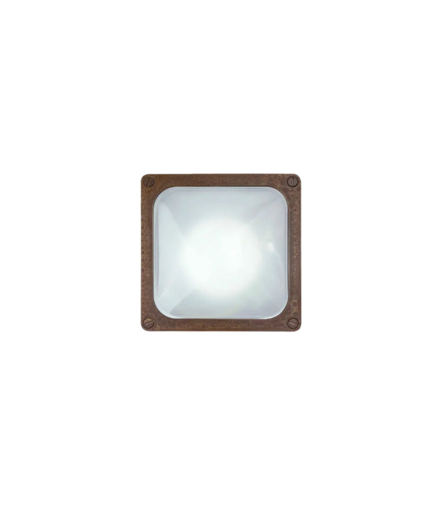 Square wall light fixture with aged brass frame on a white background