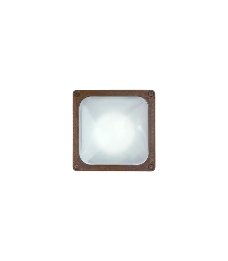 Square wall light fixture with aged brass frame on a white background